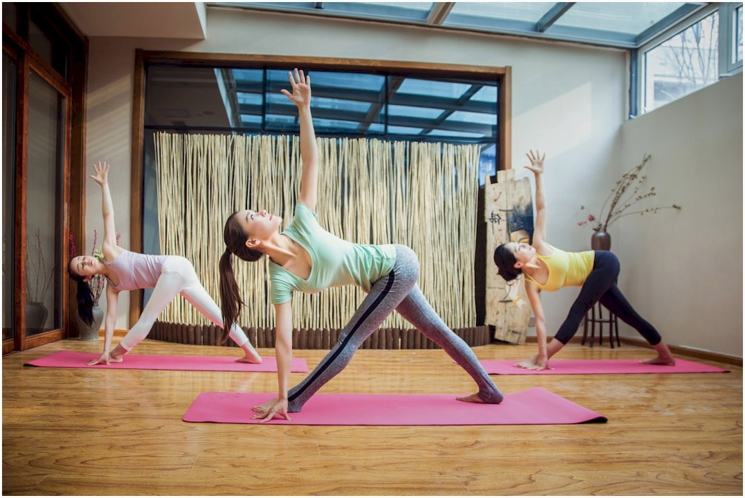 woman in gray tank top and gray leggings doing yoga