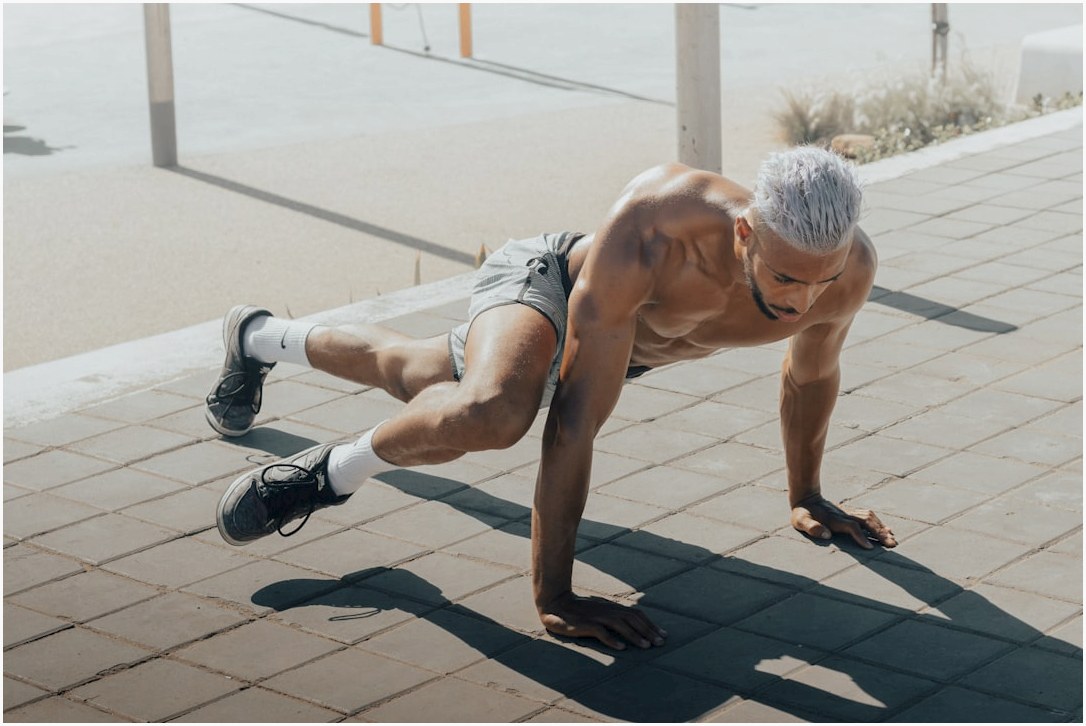 a man doing push ups on a brick sidewalk