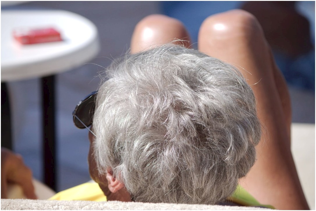 a man with grey hair and sunglasses sitting in a chair