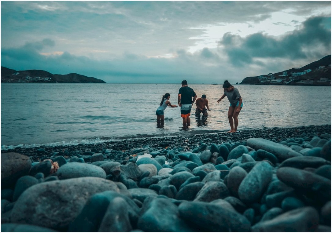 four people playing on body of water