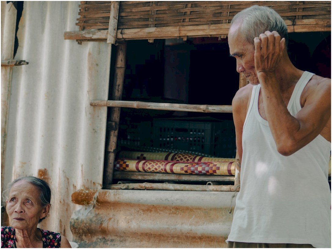 A man and a woman standing in front of a window