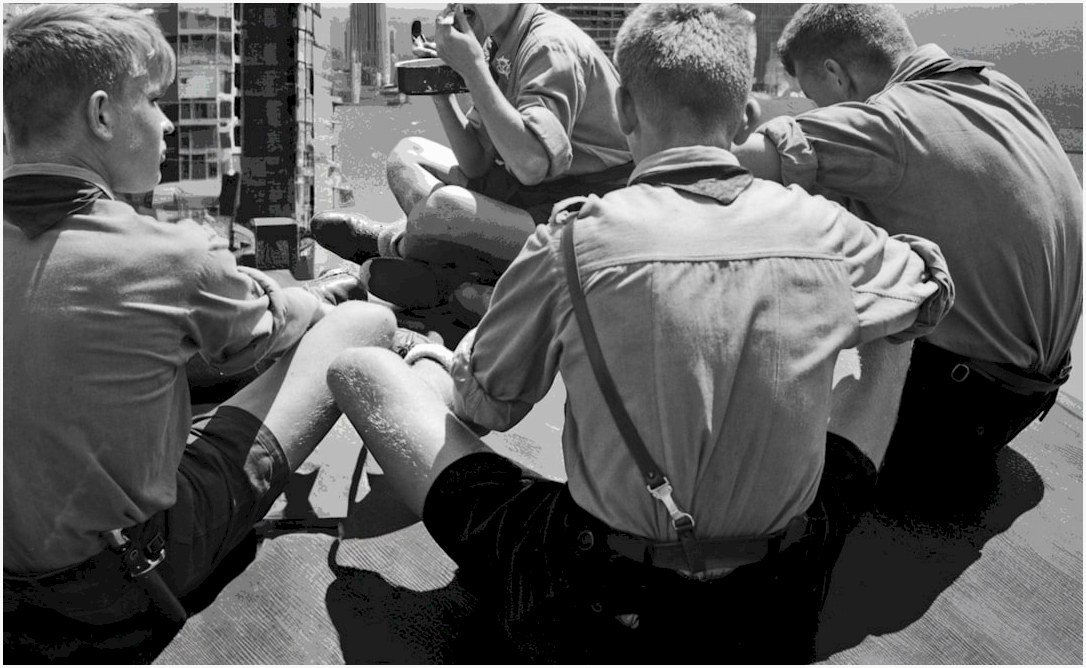 A group of men sitting on top of a wooden floor