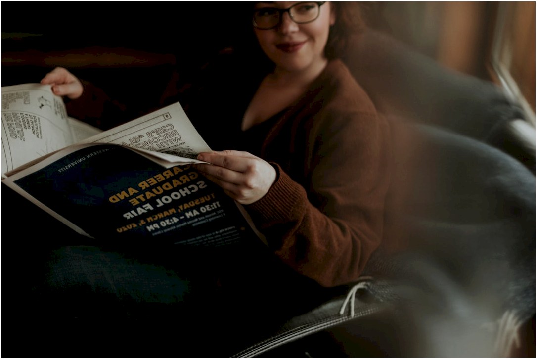 woman in brown long sleeve shirt and blue denim jeans sitting on brown leather sofa