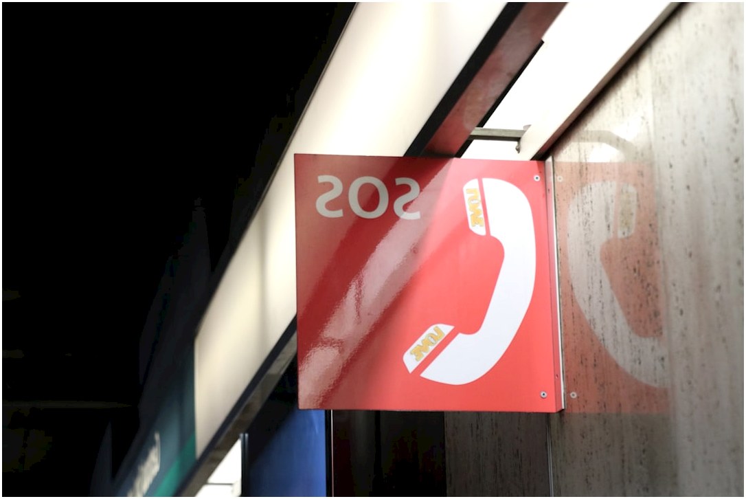 a red sign hanging from the side of a building
