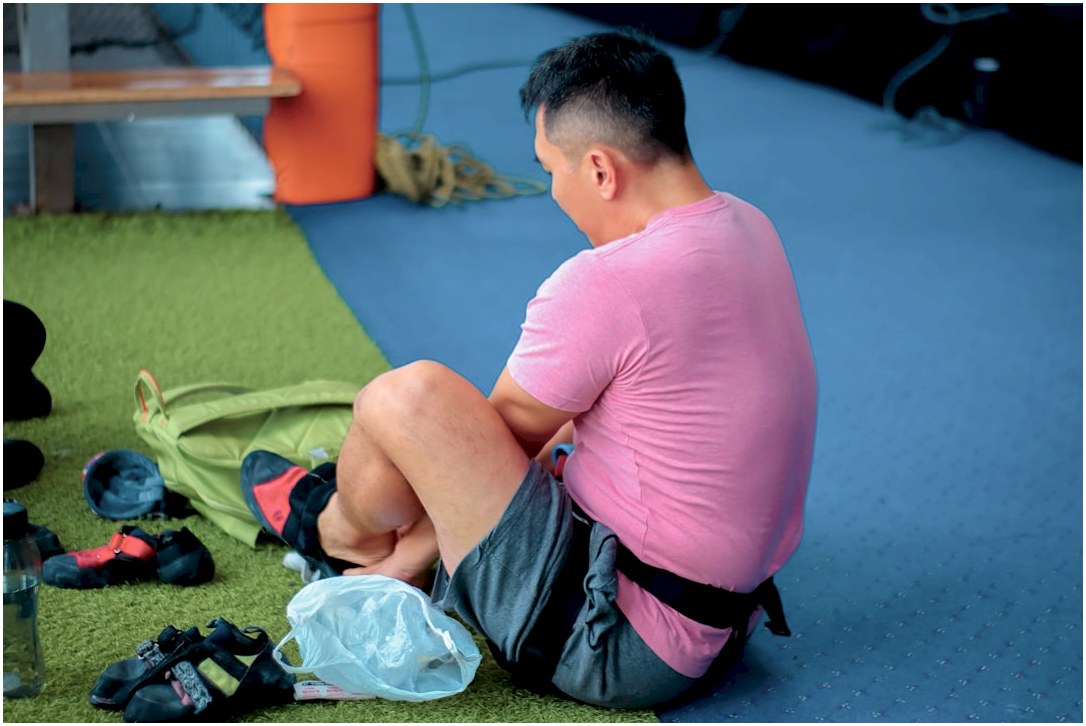 boy in pink t-shirt and black shorts sitting on green textile