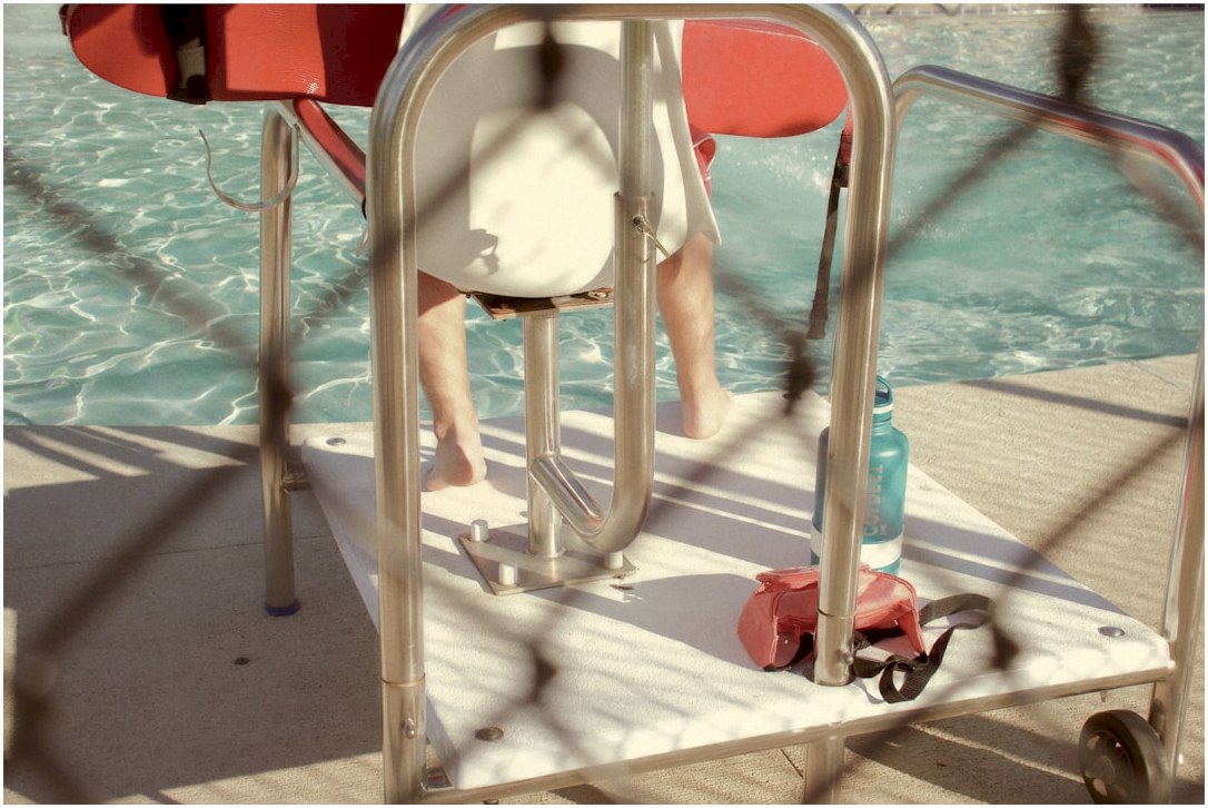 person in black shorts sitting on white chair
