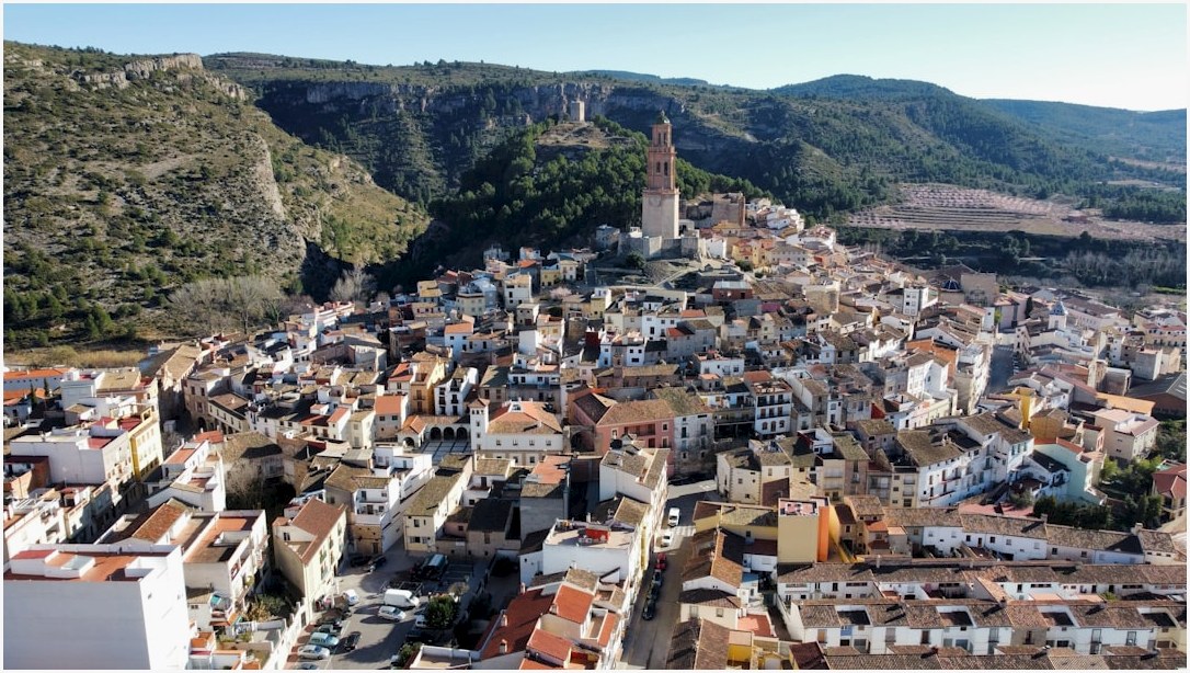 an aerial view of a city with mountains in the background
