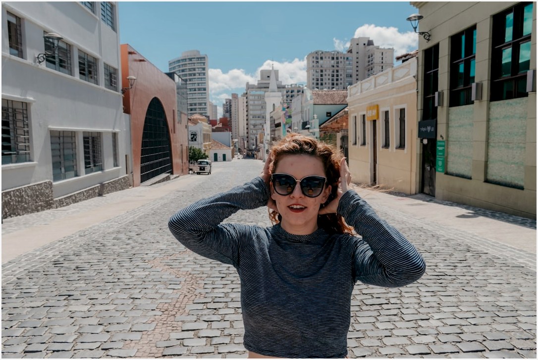 woman in black and white striped long sleeve shirt standing on sidewalk during daytime