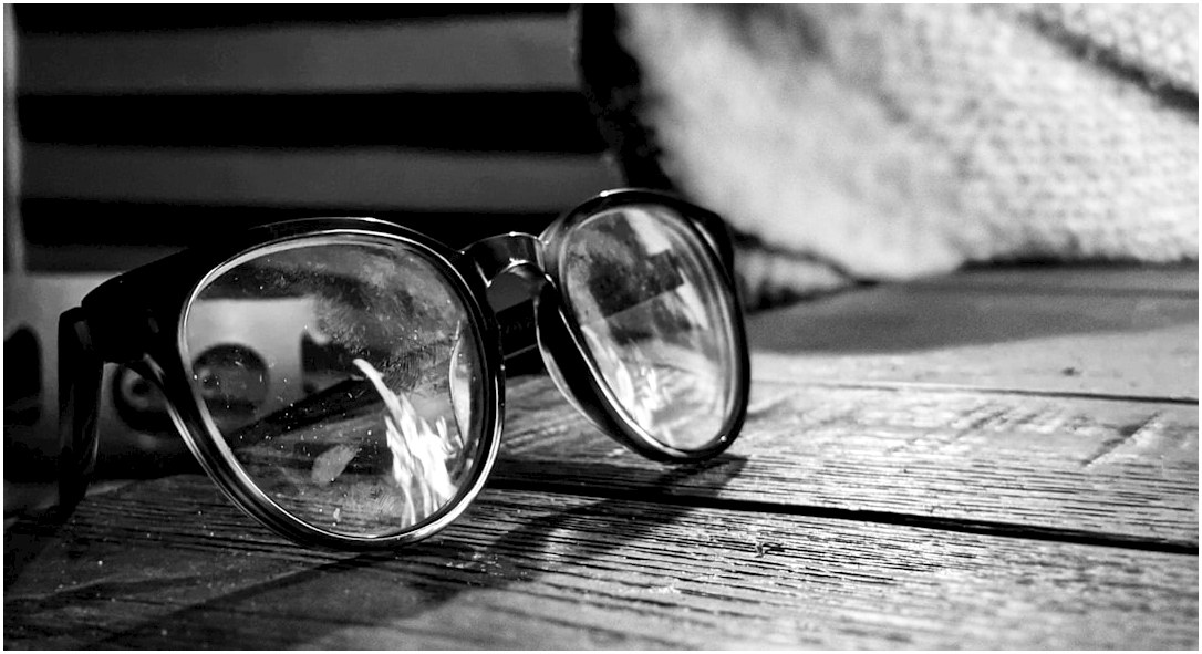 a pair of glasses sitting on top of a wooden table