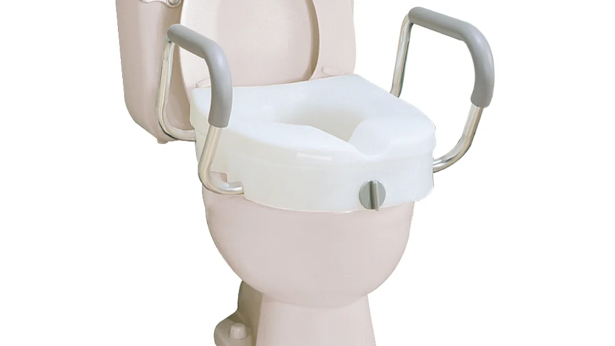Assento sanitário elevado com braços instalado sobre um vaso sanitário