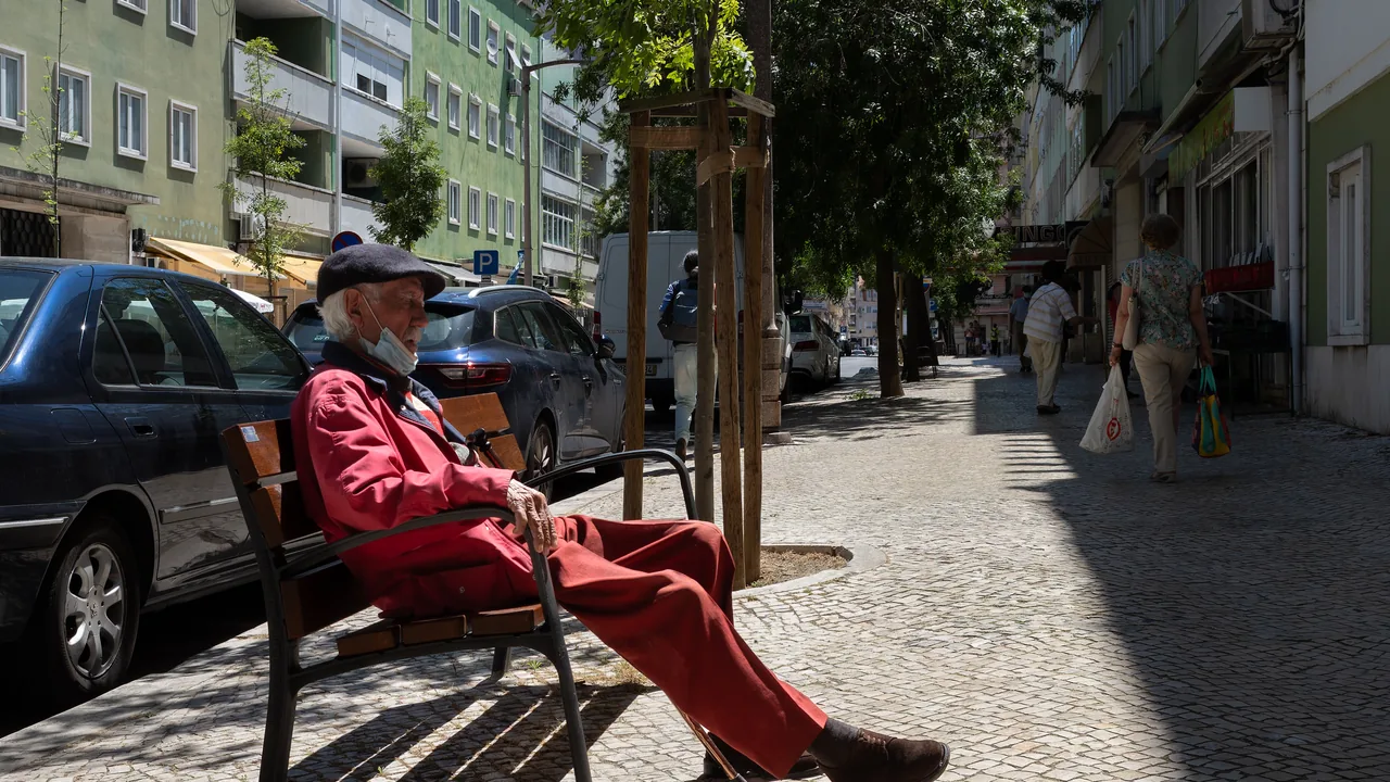 Pessoa idosa descansando em um banco durante o dia