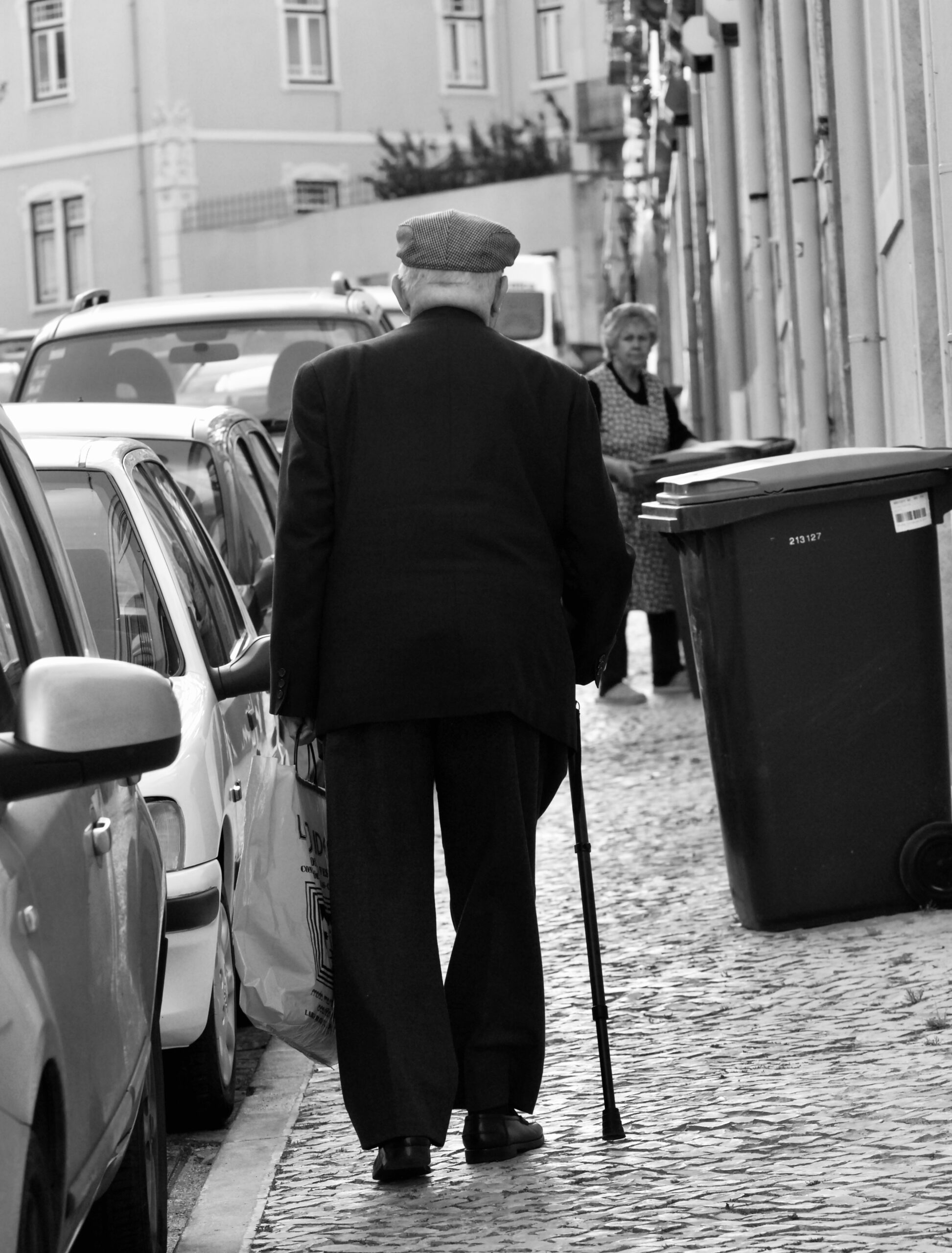 Homem idoso caminhando com bengala em uma rua