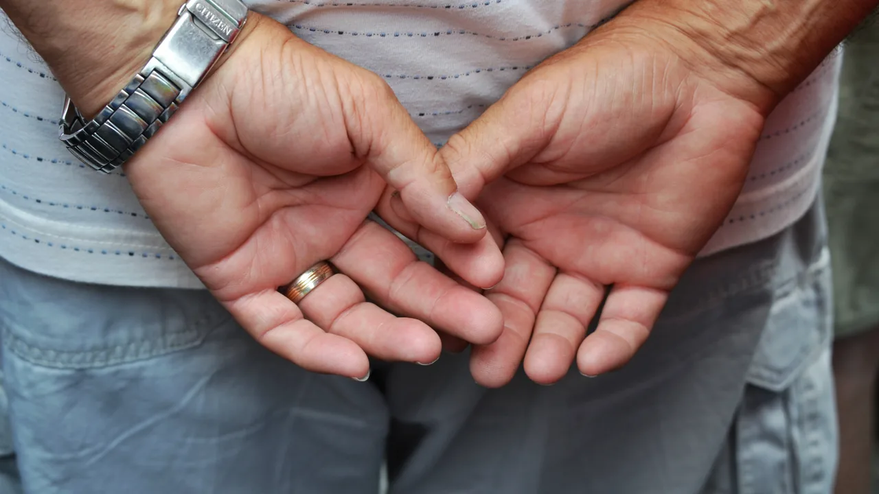Mãos de uma pessoa idosa apoiadas uma sobre a outra, destacando a região dos punhos