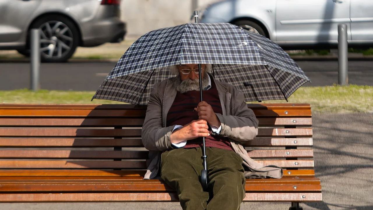 Pessoa idosa dormindo sentada sob um guarda-chuva, em imagem ilustrativa sobre sono e ronco