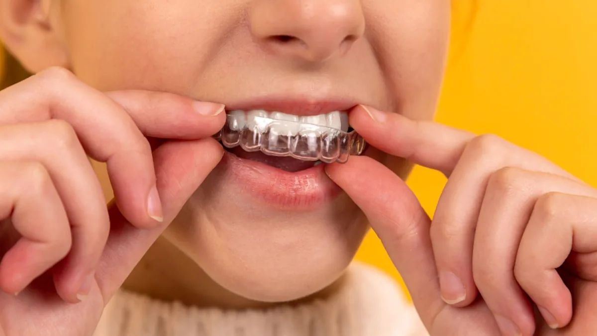 Boca sendo examinada durante cuidado de higiene oral, com dentes e gengiva em destaque