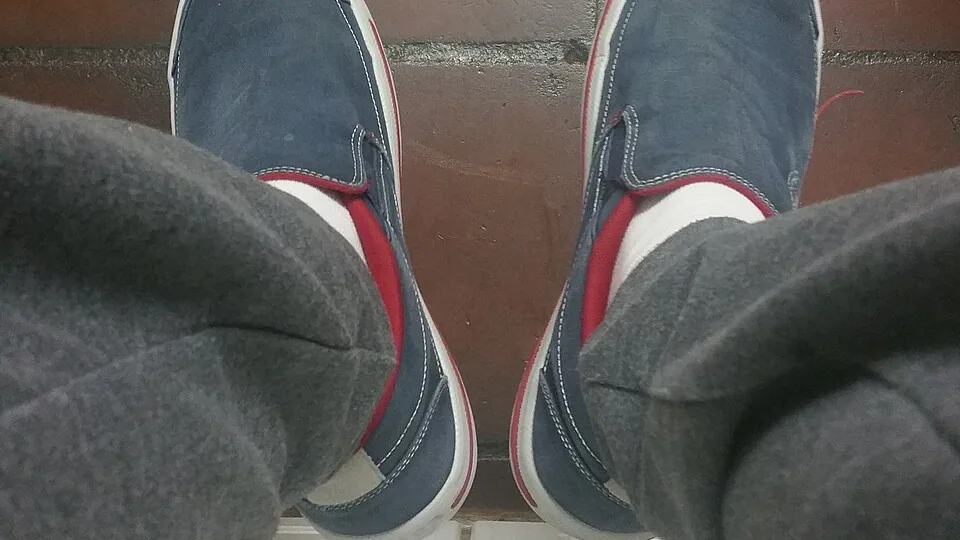 Pés calçados com sapatos fechados e meias, vistos de cima