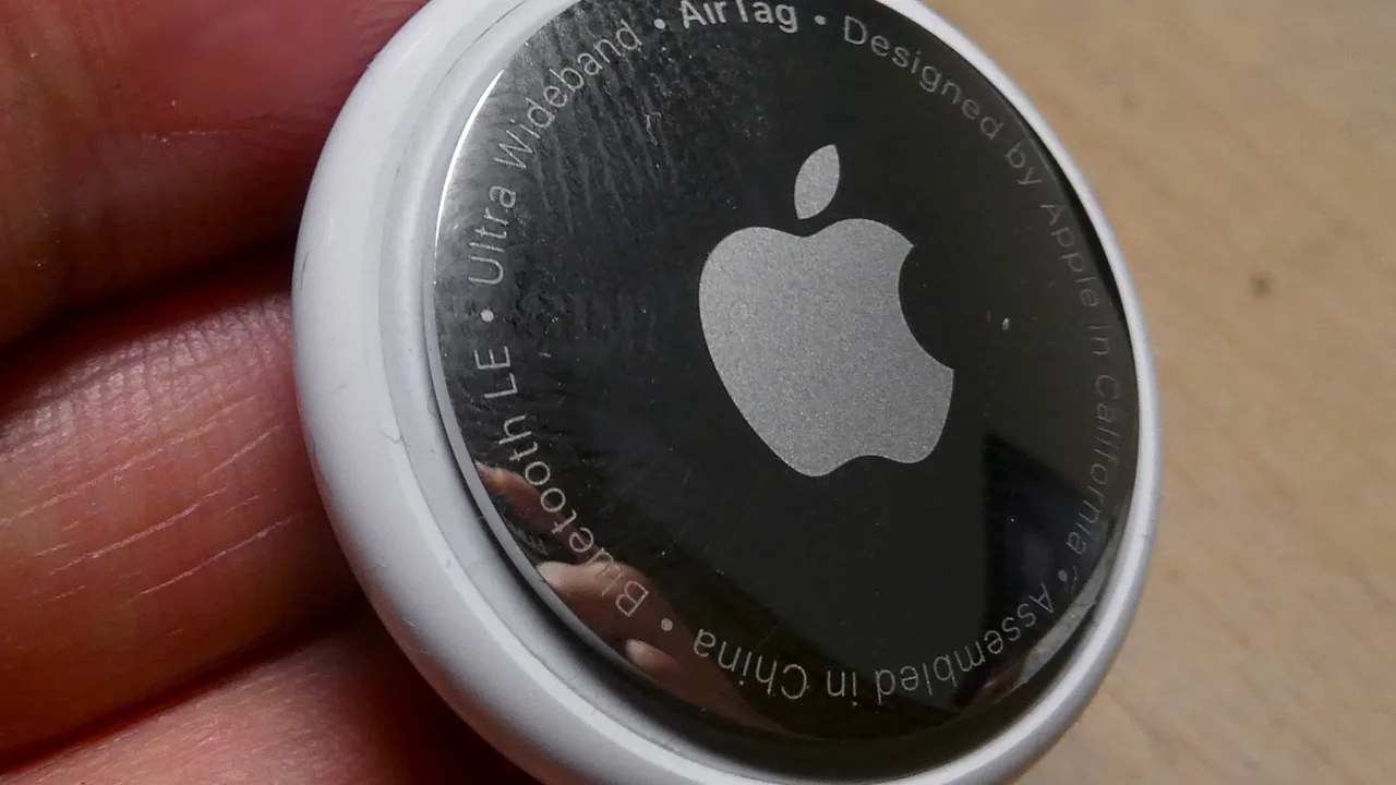 AirTag da Apple fotografado de perto, mostrando o disco branco e a parte metálica com o logotipo da Apple