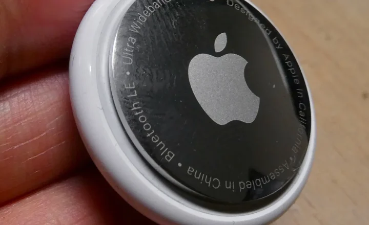 Localizador Apple AirTag branco fotografado de perto, com logotipo da Apple visível.