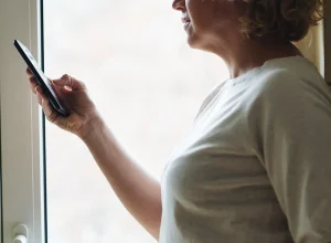 Mulher idosa usando celular para consultar informações digitais