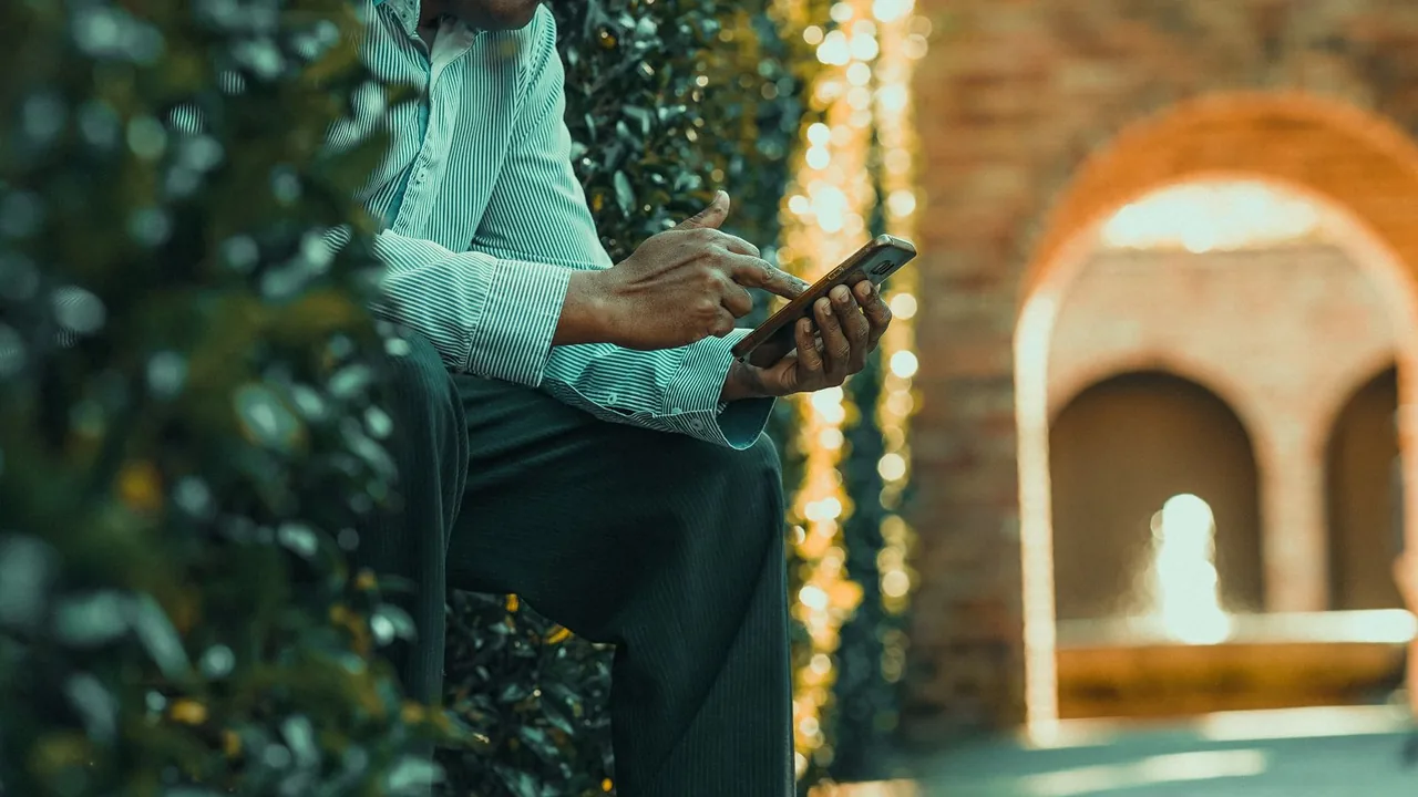 Pessoa idosa usando o celular para acessar um serviço digital
