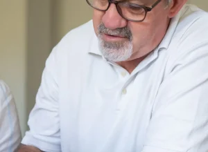 Homem idoso usando o celular para acessar um serviço digital