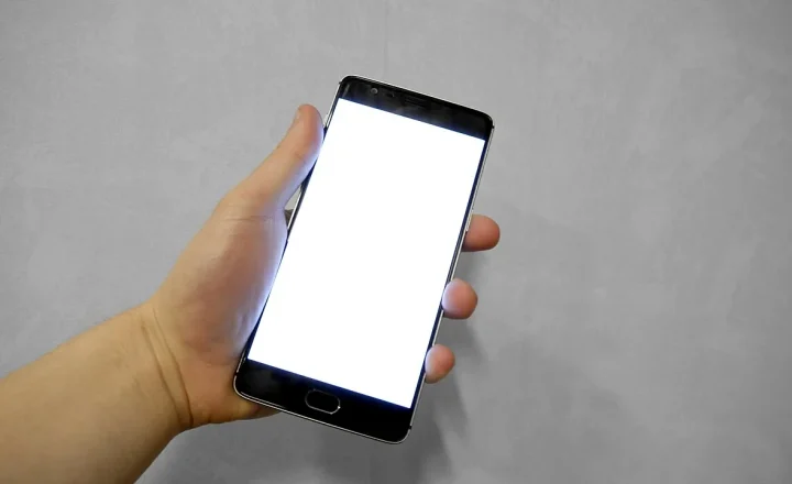 Mão segurando um smartphone com a tela branca