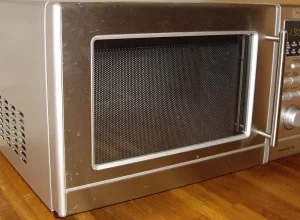 Micro-ondas de bancada visto de frente, com painel digital e porta ampla.