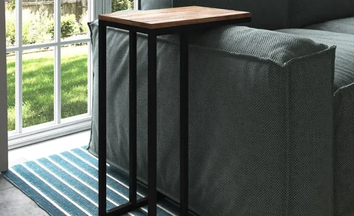 Mesa lateral preta ao lado de um sofá, com tampo de madeira