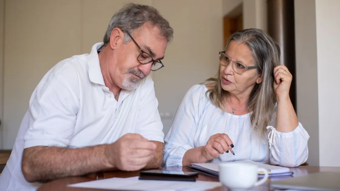 Casal idoso revisando documentos juntos em casa