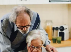 Casal idoso em casa, em momento de apoio mútuo
