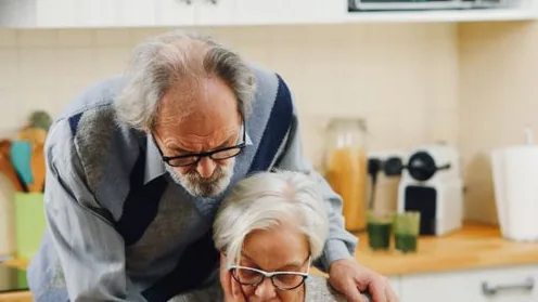 Casal idoso em casa, em momento de apoio mútuo