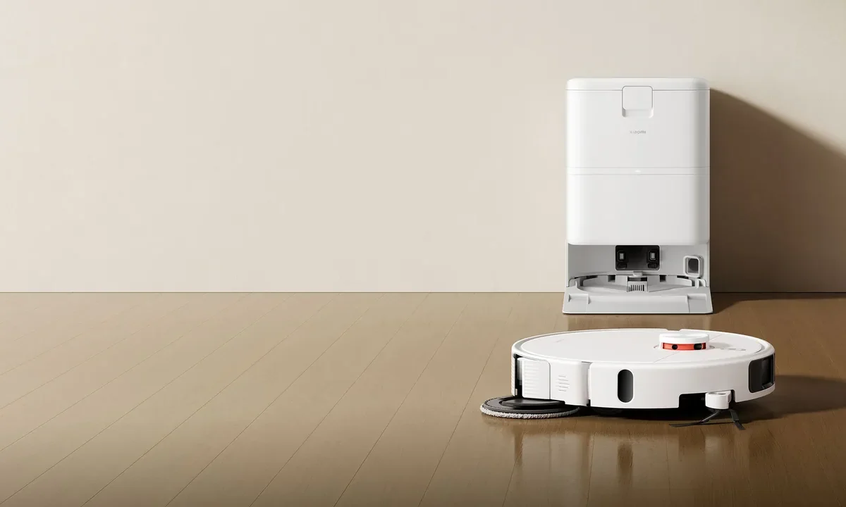 Robô aspirador Xiaomi branco junto da base de carregamento sobre piso de madeira