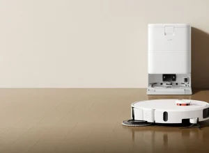 Robô aspirador Xiaomi branco junto da base de carregamento sobre piso de madeira