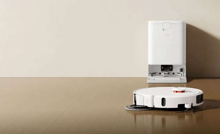 Robô aspirador Xiaomi branco junto da base de carregamento sobre piso de madeira